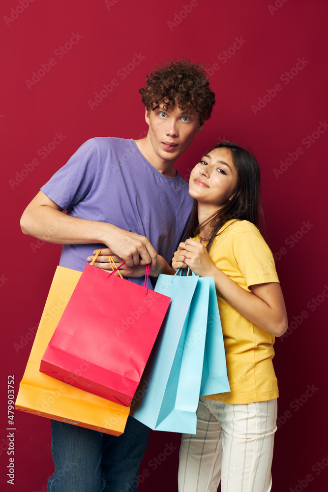 cute young couple in colorful T-shirts with bags Shopping isolated background unaltered