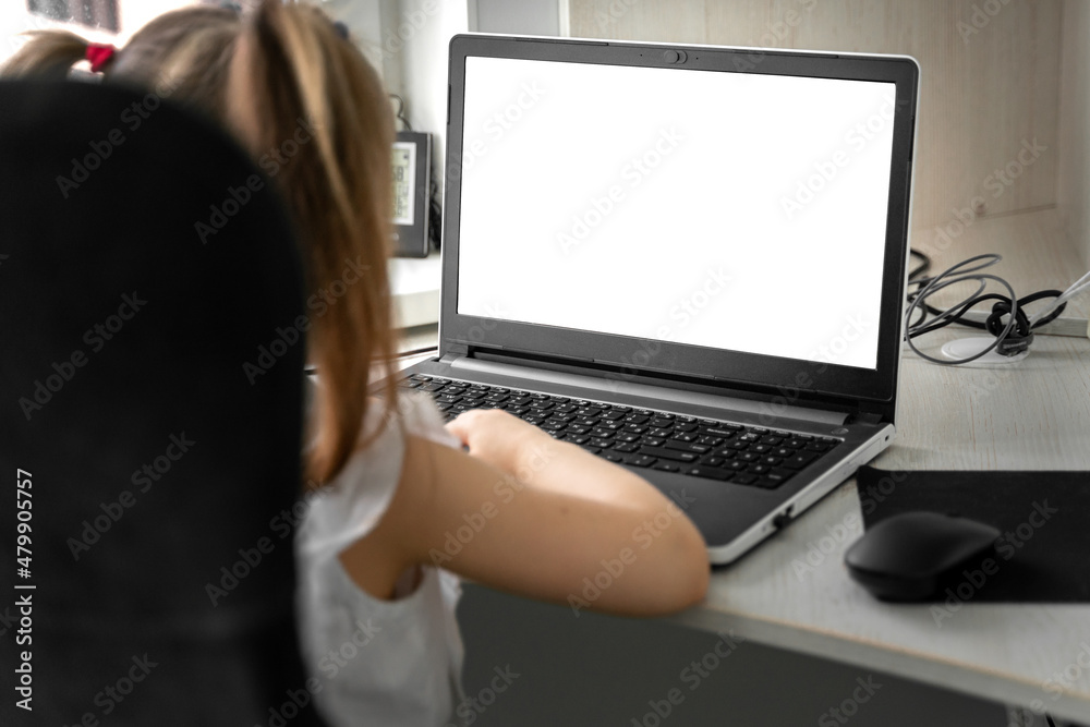 cute little caucasian girl studying online at home. screen mockup cute little caucasian girl studying online at home. screen mockup