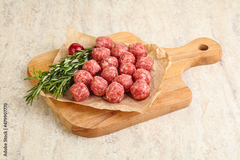 Raw uncooked beef meatballs served rosemary Raw uncooked beef meatballs served rosemary