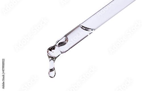 close-up of a serum pipette with a falling drop on a white background photo