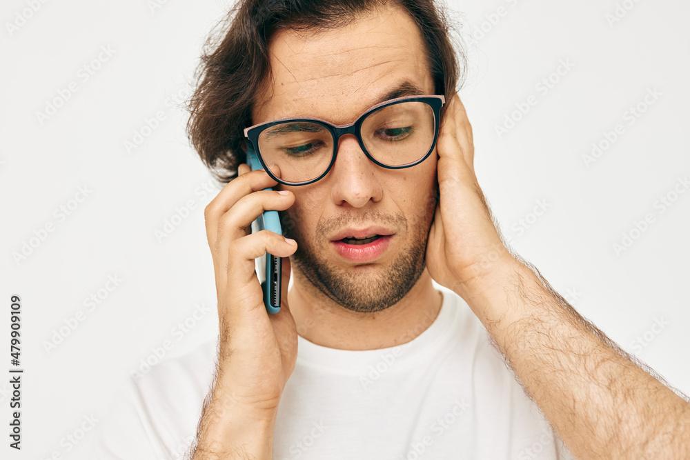 handsome man in a white T-shirt communication by phone isolated background handsome man in a white T-shirt communication by phone isolated background
