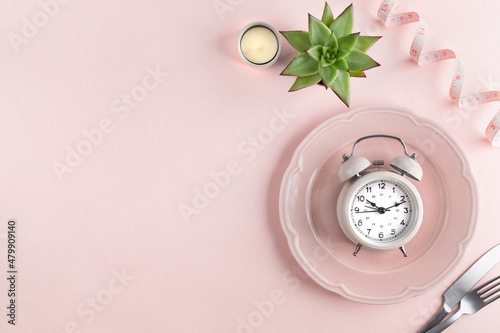 Diet concept. Composition with cutlery, measuring tape and alarm clock on color background. Copy space