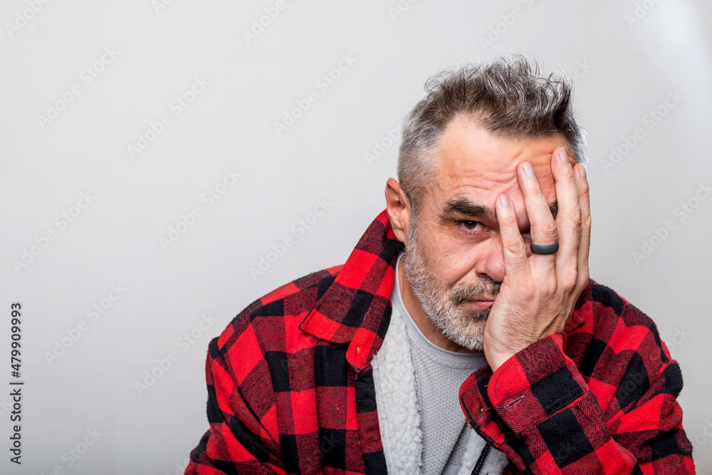 Portrait of a cringe man in a warm buffalo check lumberjack shirt Portrait of a cringe man in a warm buffalo check lumberjack shirt
