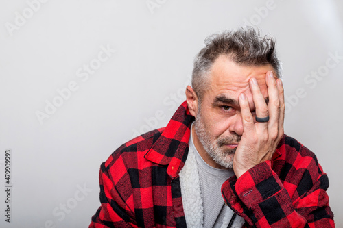 Portrait of a cringe man in a warm buffalo check lumberjack shirt