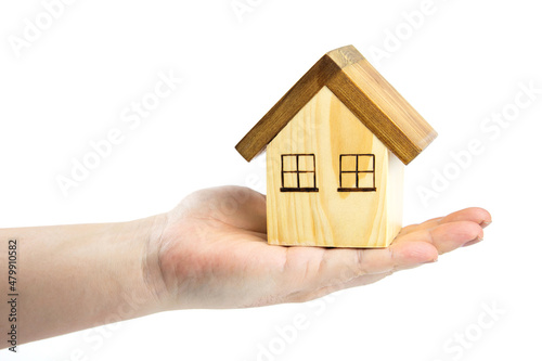 Wooden house in hand isolated on white background. concept of house trading, home building planning real estate business