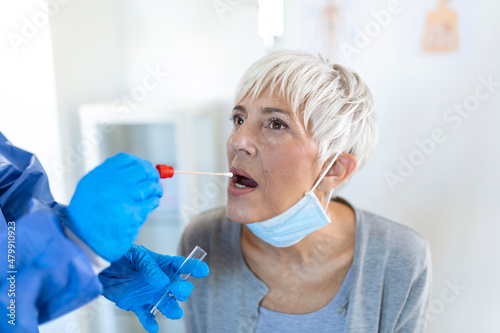 Physician wearing personal protective equipment performing a Coronavirus COVID-19 PCR test  patient nasal NP and oral OP swab sample specimen collection process  viral rt-PCR DNA diagnostic procedure
