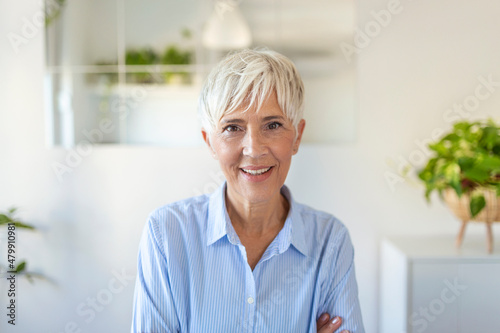 Senior woman looking at camera. Successful mature business woman. Happy old professor with gray hair.