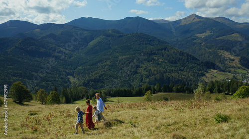 Family walking beautiful landscape background with green forest hills pikes 