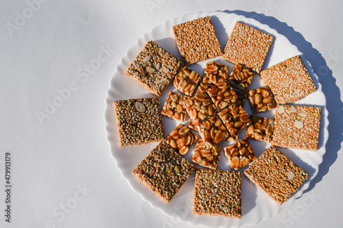 Tasty Indian sesame brittles and Peanut jaggery candy bars known as Til chikki and Peanut or shenga singhdana chikki decorated arranged served during winters sankranti uttarayan pongal festival food photo
