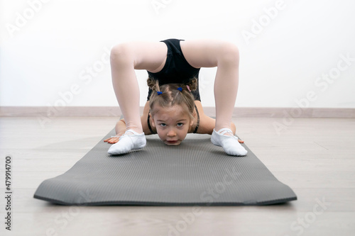 flexible child girl doing gymnastic exercises