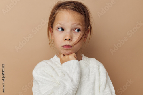 pretty young girl in white sweater posing hand gestures beige background