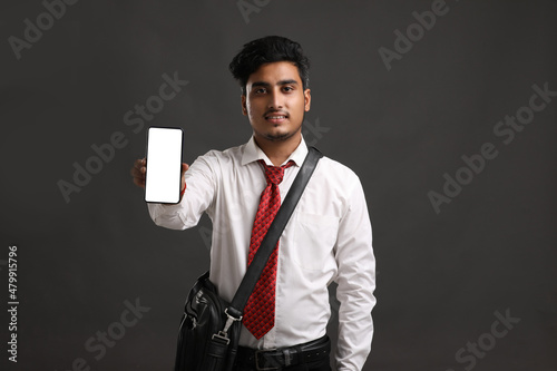 Young indian officer or student showing smartphone screen