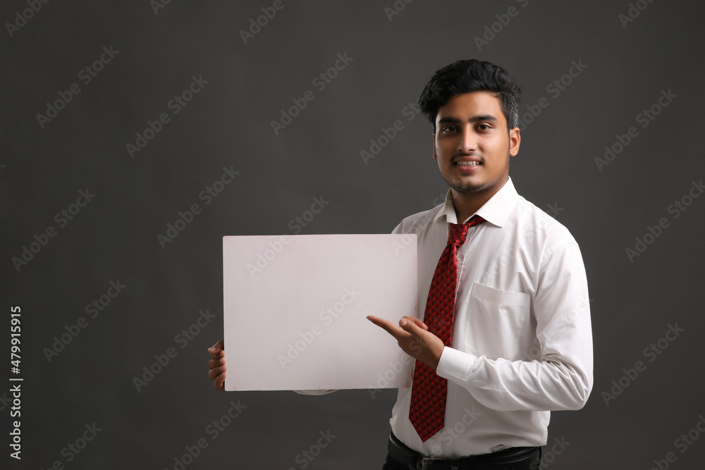Young indian business man holding blank sign board. Young indian business man holding blank sign board.