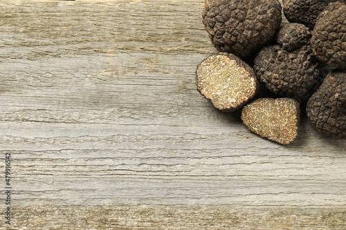 Black truffles on wooden table, flat lay. Space for text