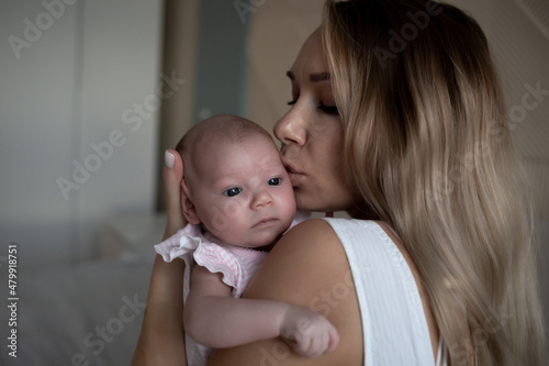 young beautiful woman kisses her little cute daughter. family portrait