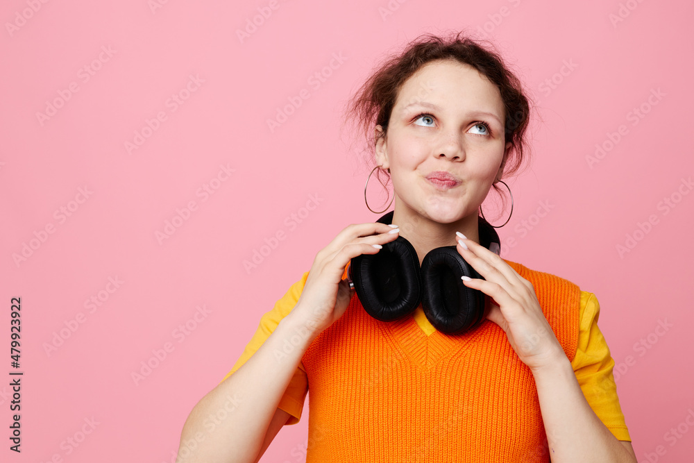 Obraz premium funny girl in an orange jacket headphones music entertainment Lifestyle unaltered