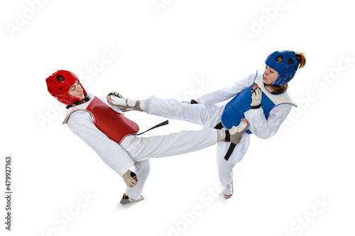 Top view of two young women, taekwondo athletes training together isolated over white background. Concept of sport, skills