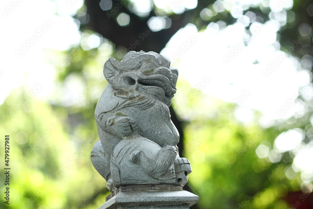 Small traditional Chinese sculpture against blurry green background Small traditional Chinese sculpture against blurry green background