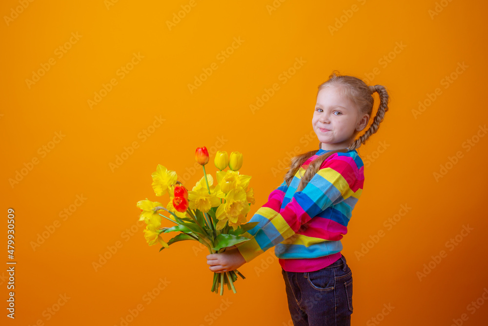 a cute little girl in a multicolored sweater holds a bouquet of spring flowers on a yellow background a cute little girl in a multicolored sweater holds a bouquet of spring flowers on a yellow background