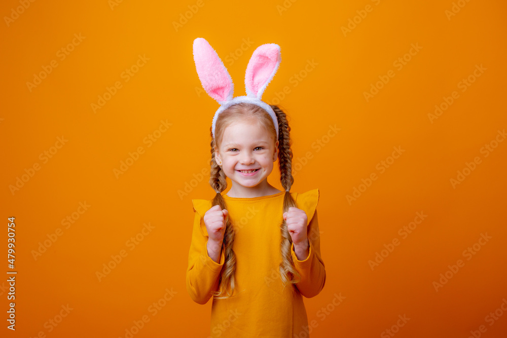 cute little girl with Easter bunny ears,on a yellow background, shows different emotions, joy, surprise, happiness, dreaming,