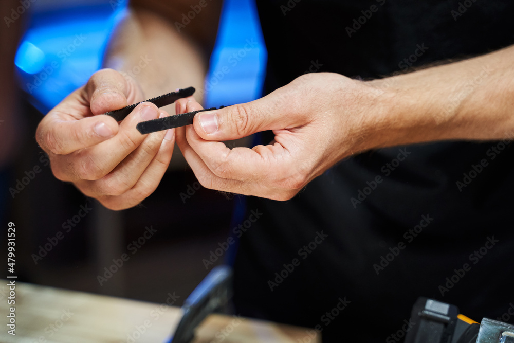 different blades for a jigsaw in men's hands