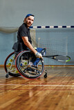 Young man in wheelchair playing tennis on court. Wheel Chair Tennis.