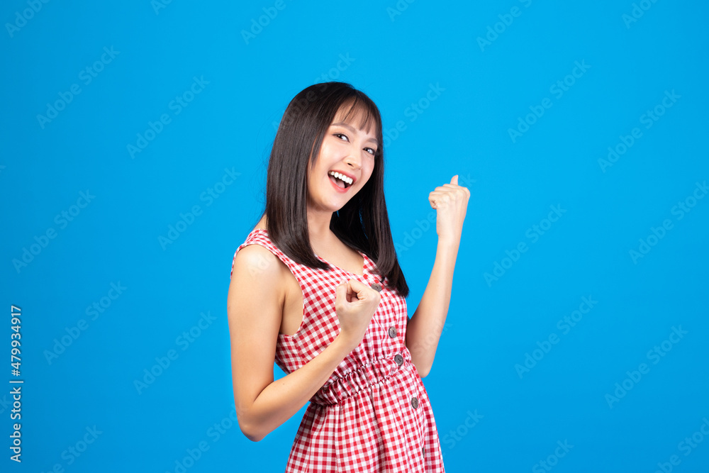 Image of feeling excited, shock, surprise, success and happy. Young asian woman standing on blue background. Female face expressions and emotions body language concept. Image of feeling excited, shock, surprise, success and happy. Young asian woman standing on blue background. Female face expressions and emotions body language concept.