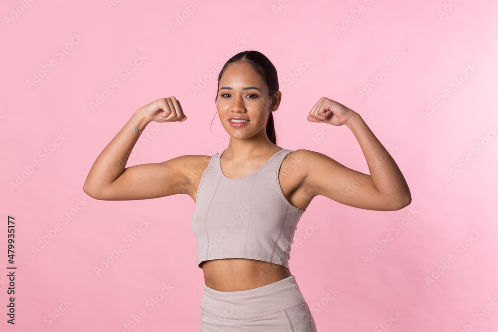 Young girl doing gymnastic exercises and stretching before starting sport activity on a pink background. Young girl doing gymnastic exercises and stretching before starting sport activity on a pink background.