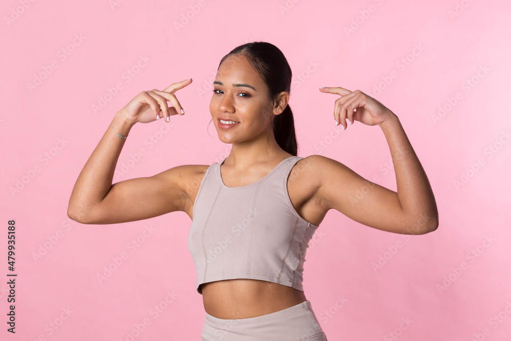 Young girl doing gymnastic exercises and stretching before starting sport activity on a pink background. Young girl doing gymnastic exercises and stretching before starting sport activity on a pink background.