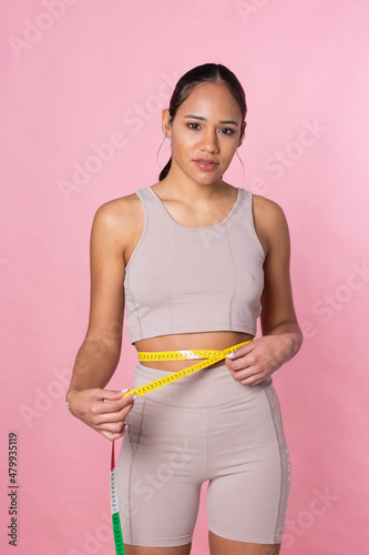 Young girl taking her measurements with a tape measure © Jorge