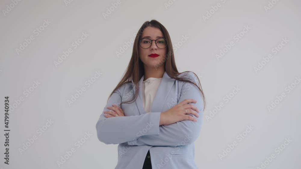 A beautiful young business woman in black glasses raises her eyebrows in surprise and laughs contagiously. Feminism and career concept A beautiful young business woman in black glasses raises her eyebrows in surprise and laughs contagiously. Feminism and career concept
