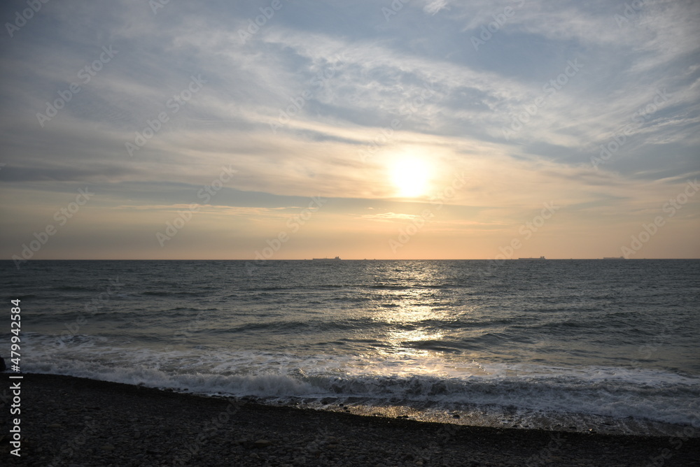 The last rays of the setting sun against the background of the calm running of the sea waves. The last rays of the setting sun against the background of the calm running of the sea waves.