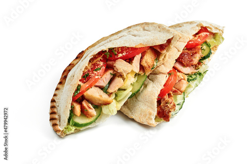 Pita with chicken and cheese, fresh vegetables and red sauce on a white plate. Photo for the menu. Isolated