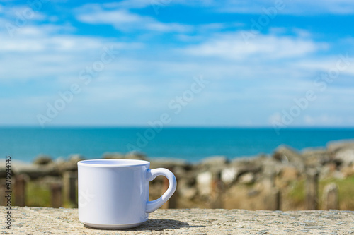 Empty white cup on blurred beach background