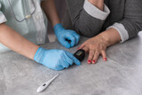 Close-up photo of a female hands. Woman doctor measures the patient's pulse and oxygen saturation to middle aged woman using a pulse oximeter, healthcare concept