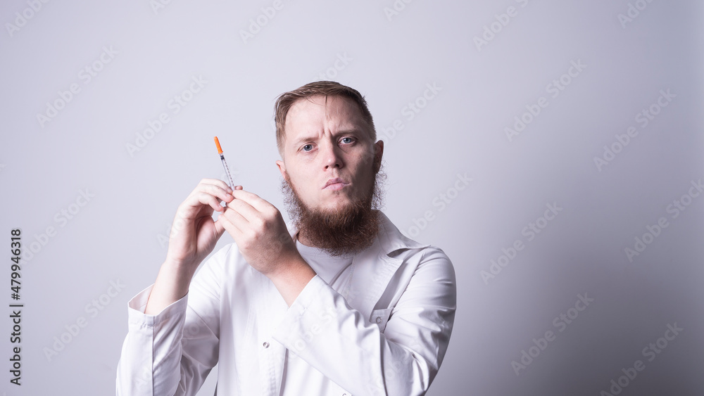 a young doctor in a mask holds an inzulin syringe a young doctor in a mask holds an inzulin syringe