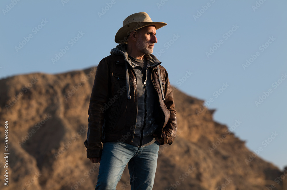 Naklejka premium Adult man in cowboy hat in Tabernas Desert, Almeria, Spain