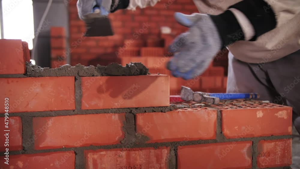 builder lays red brick close-up
