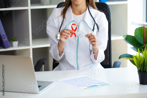 Doctor hands holding red AIDS awareness ribbon