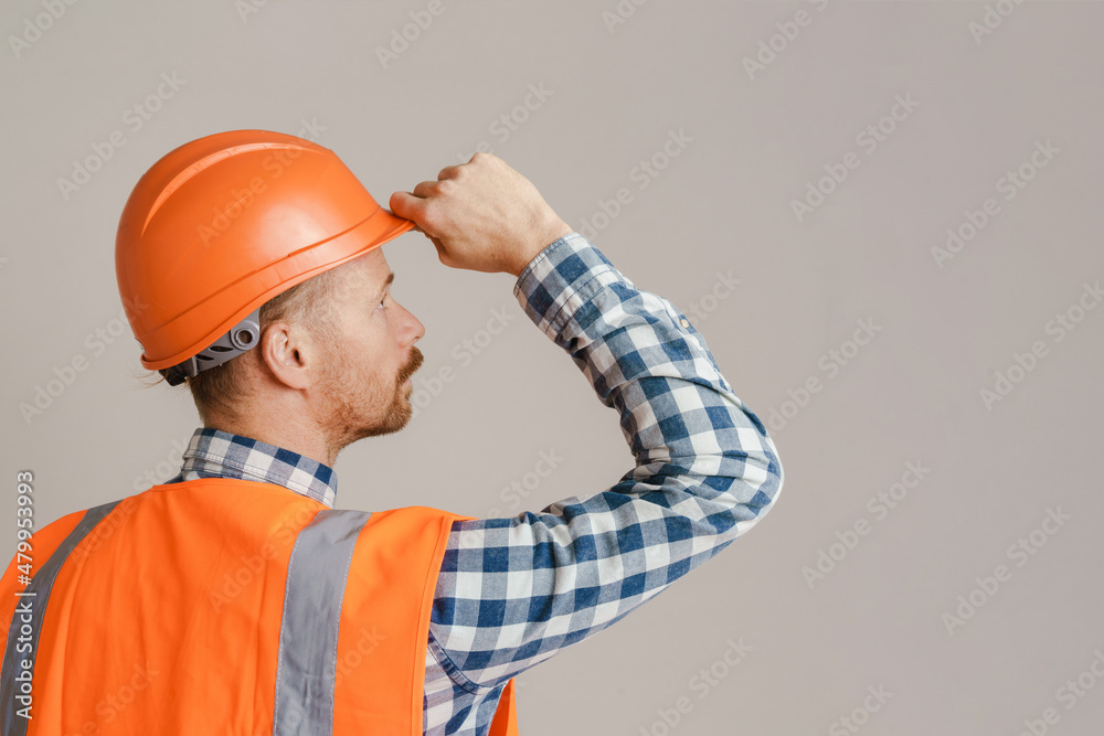 White man worker wearing helmet and vest looking aside White man worker wearing helmet and vest looking aside