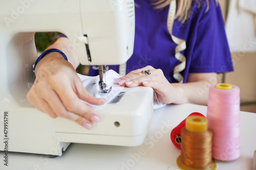 a woman sews on a sewing machine