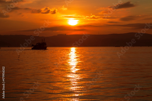 big ship with sunset. orange sky and clouds