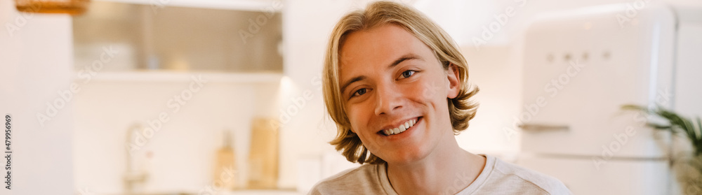 European blonde man smiling and looking at camera in home European blonde man smiling and looking at camera in home