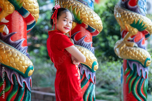 Portrait smiles Cute little Asian girl wearing red cheongsam dress traditional decoration for Chinese new year festival celebrate culture of china at Chinese shrine