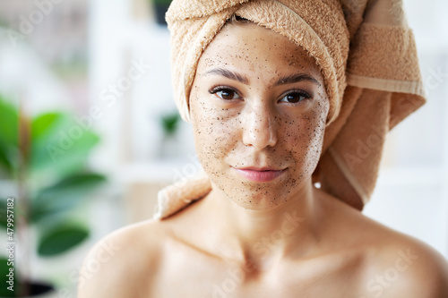 Beautiful young woman with scrub mask in spa salon
