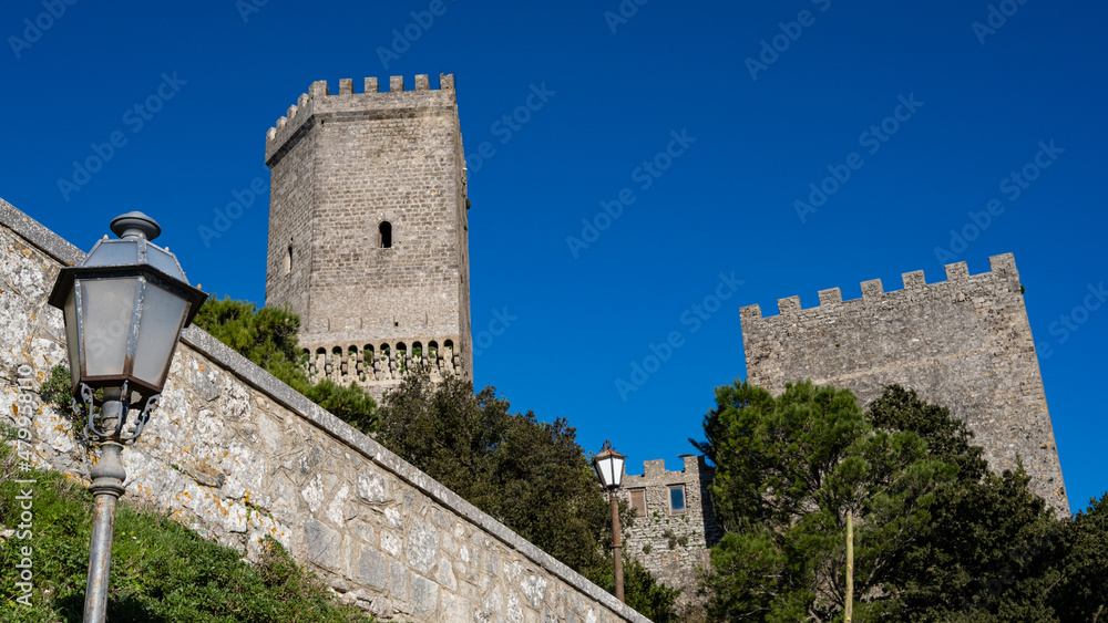 Erice, Sicily, Italy. Glimpse of the castle of Venus with street lamps and blue sky