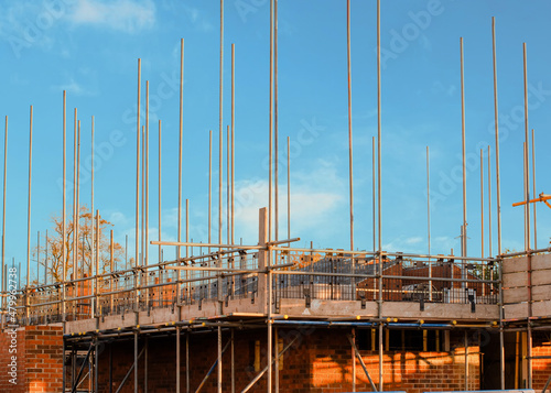New residential house under construction and scaffolds erected around it to provide safe working platform to brickl and other construction workers © Iryna