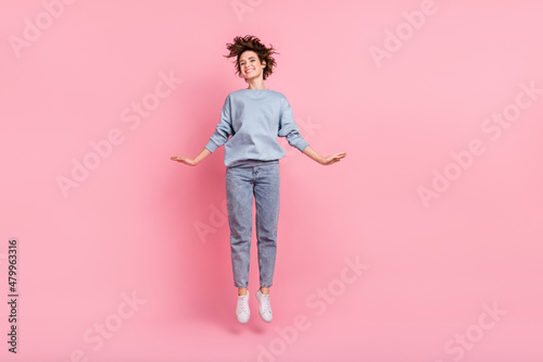 Full length photo of hooray young lady jump wear jumper jeans footwear isolated on pink background