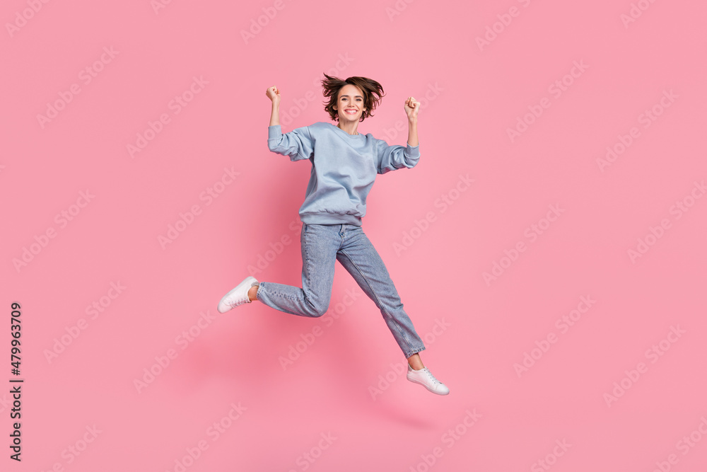 Full length photo of celebrate young lady jump yell wear jumper jeans footwear isolated on pink background