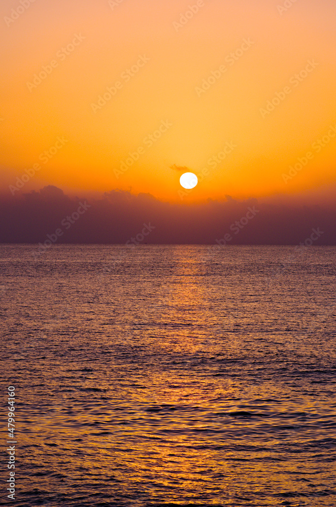 The sun's disc rises over the cloud. Scenic morning landscape view of the sea.  The Mediterranean Sea near Mersin, Turkey. Travel and tourism concept